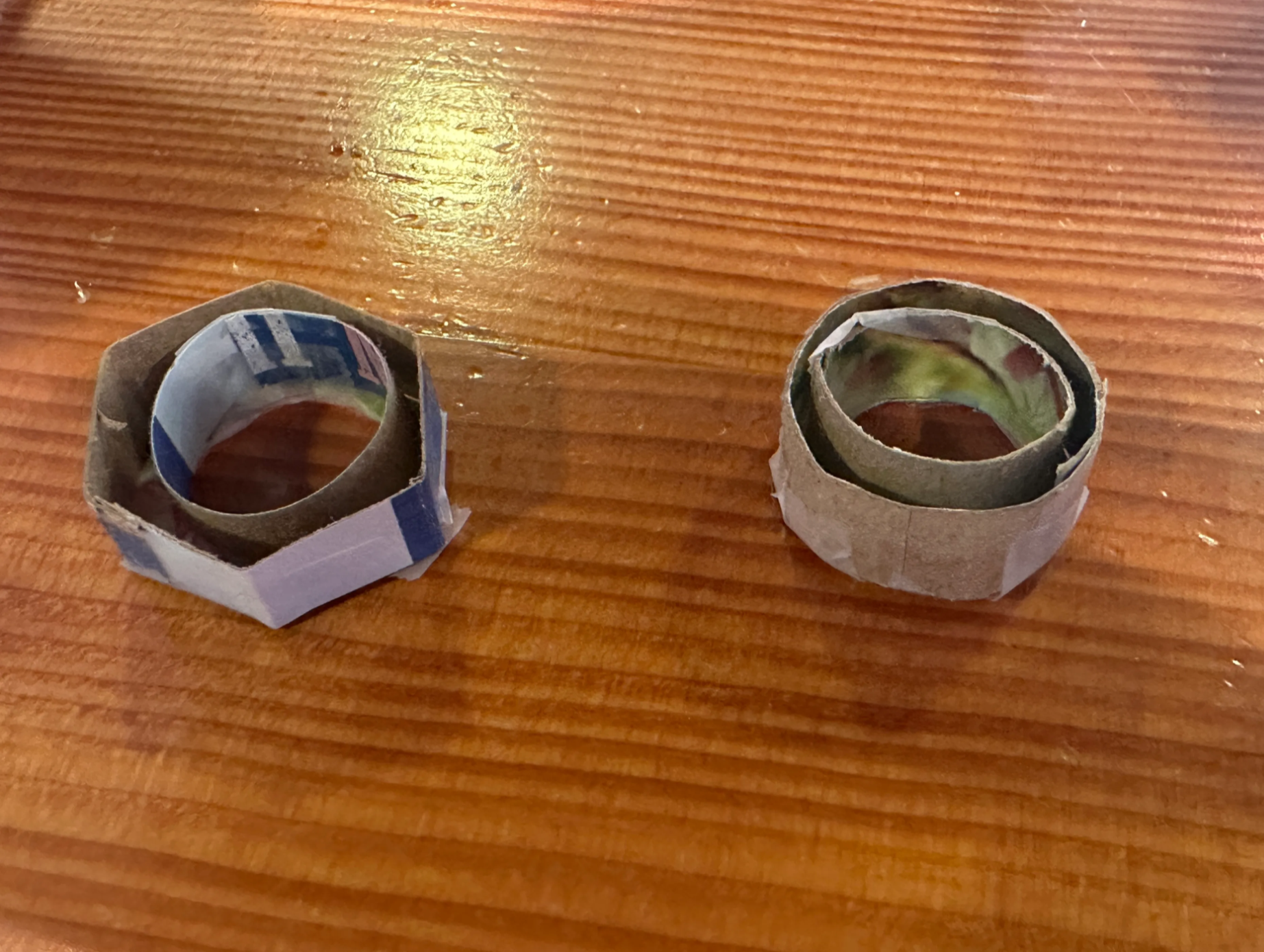 Cardboard prototypes — circular and hexagonal forms on a faucet